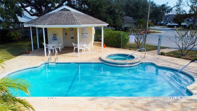 community pool with a community hot tub, a patio area, and fence