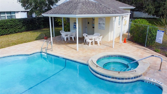 pool featuring a community hot tub, fence, and a patio