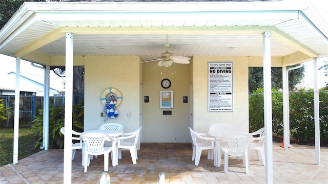 sunroom with ceiling fan and beamed ceiling