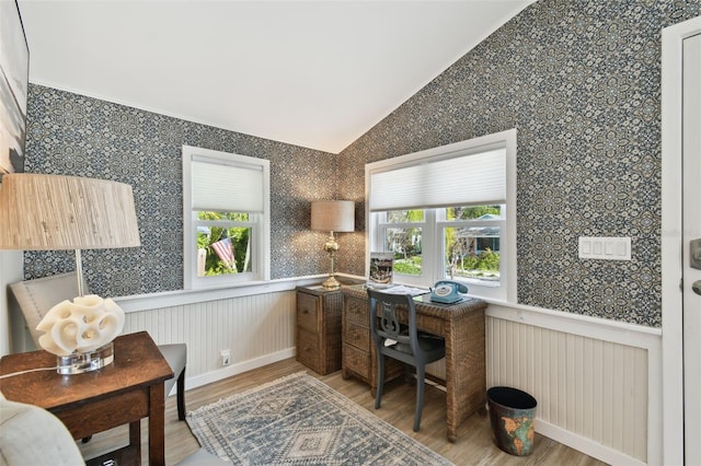 office with plenty of natural light, light wood-style floors, wainscoting, and vaulted ceiling