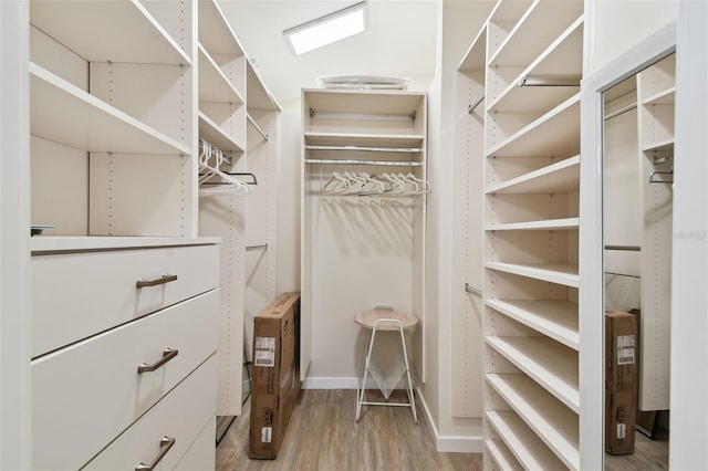 walk in closet with wood finished floors