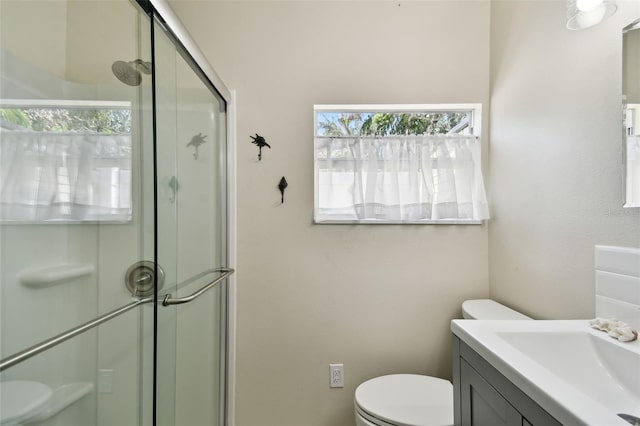 full bathroom featuring a shower stall, toilet, and vanity