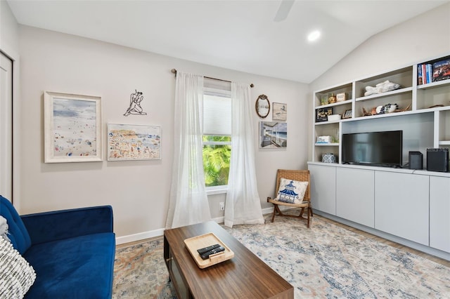 living room with lofted ceiling, wood finished floors, a ceiling fan, and baseboards