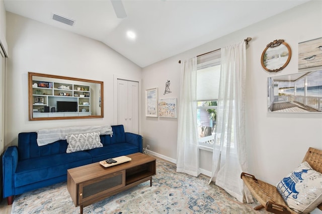 living area featuring visible vents, a ceiling fan, baseboards, and vaulted ceiling