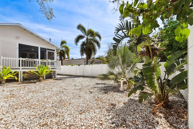 view of yard with fence and a sunroom