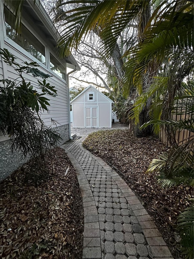 view of yard with an outbuilding, a storage unit, and fence