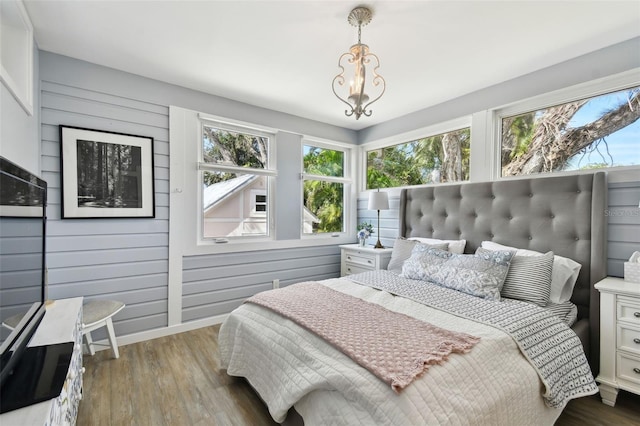 bedroom with multiple windows, baseboards, and dark wood-style flooring