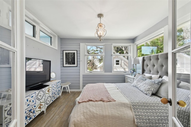 bedroom featuring dark wood finished floors and a notable chandelier