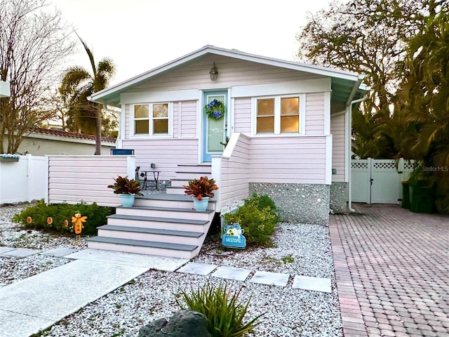 bungalow-style home featuring fence and a gate