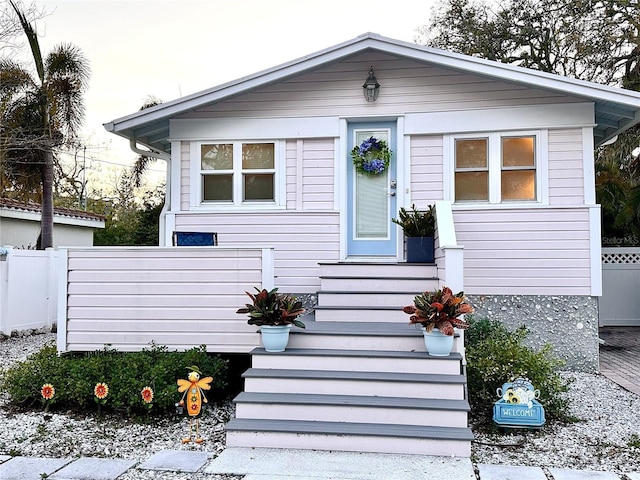 view of front of property with entry steps and fence