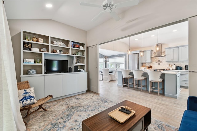 living area featuring lofted ceiling, recessed lighting, light wood-style floors, and ceiling fan