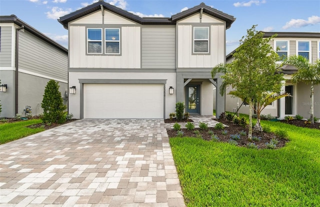 10356 Cross River Trl, Parrish, FL 34219 - view of front of home with decorative driveway, a front lawn, a garage, and board and batten siding