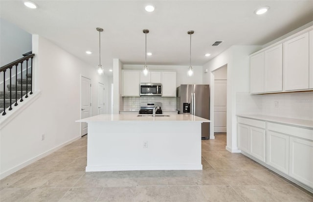10356 Cross River Trl, Parrish, FL 34219 - kitchen with stainless steel appliances, decorative backsplash, light countertops, a kitchen island with sink, and white cabinetry