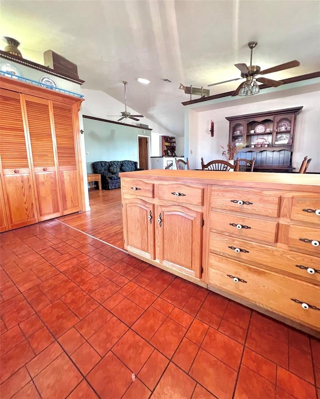 kitchen with lofted ceiling, dark tile patterned floors, and a ceiling fan