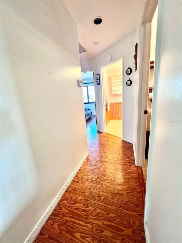 hallway featuring light wood-style floors and baseboards