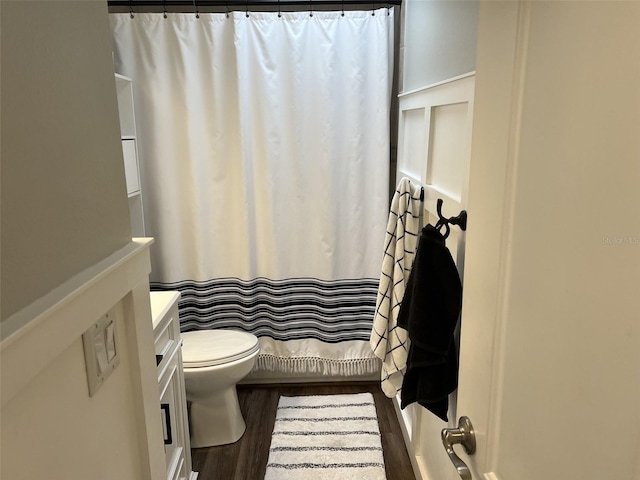 full bathroom with toilet, a shower with shower curtain, wood finished floors, and vanity