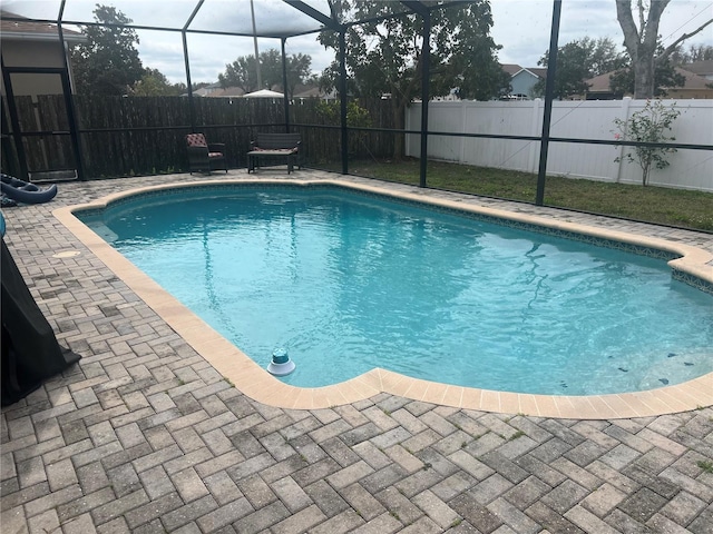 view of swimming pool featuring a patio area and glass enclosure