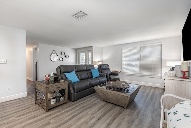 living room featuring baseboards, visible vents, and light wood-style floors