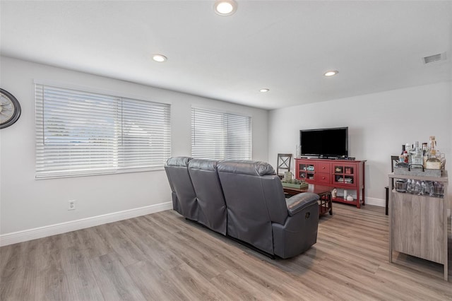 living area featuring visible vents, baseboards, recessed lighting, and light wood finished floors