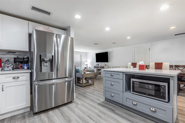 kitchen featuring light countertops, visible vents, stainless steel appliances, and white cabinetry