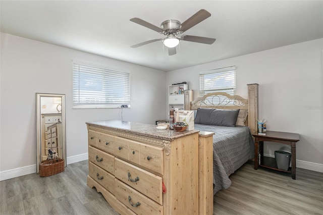 bedroom featuring baseboards, ceiling fan, and light wood-style flooring