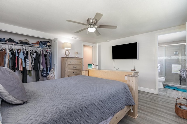 bedroom with a ceiling fan, wood finished floors, baseboards, connected bathroom, and a closet