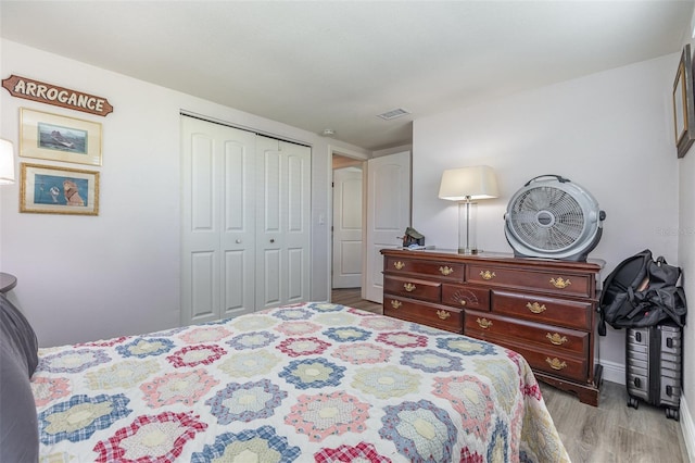 bedroom featuring visible vents, a closet, and light wood finished floors