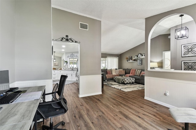 office featuring hardwood / wood-style flooring, a textured ceiling, a notable chandelier, and lofted ceiling