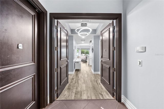 hall featuring baseboards and light tile patterned flooring