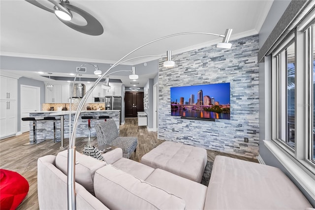 living room featuring light wood-style flooring and crown molding