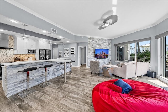 living room with visible vents, crown molding, baseboards, and ceiling fan