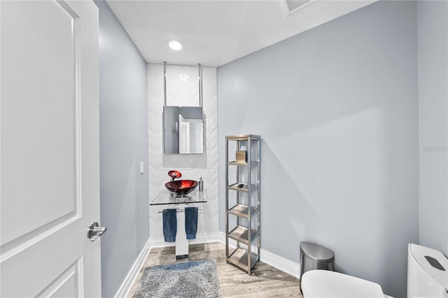 bathroom featuring baseboards, toilet, and wood finished floors