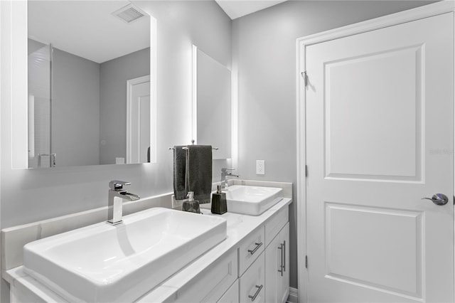 full bath featuring visible vents, a sink, and double vanity