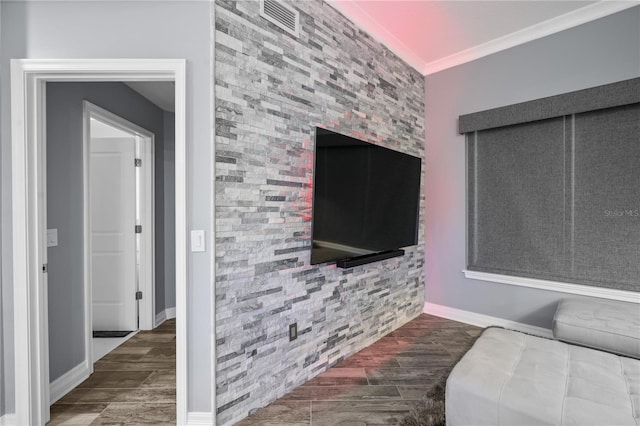 living room with an accent wall, ornamental molding, and wood finish floors