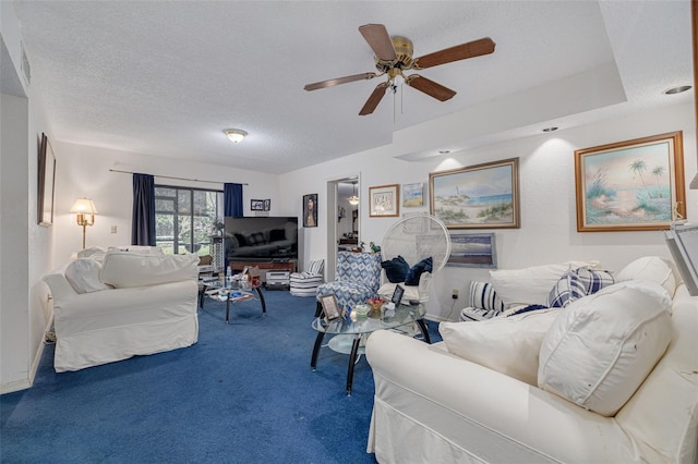 carpeted living area featuring a ceiling fan and a textured ceiling