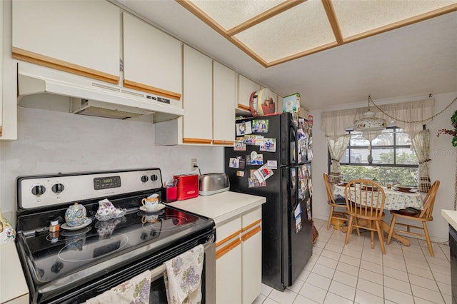 kitchen featuring freestanding refrigerator, stainless steel electric range, light countertops, under cabinet range hood, and light tile patterned flooring