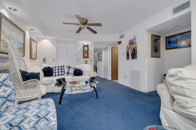 living area with carpet floors, visible vents, and a textured ceiling