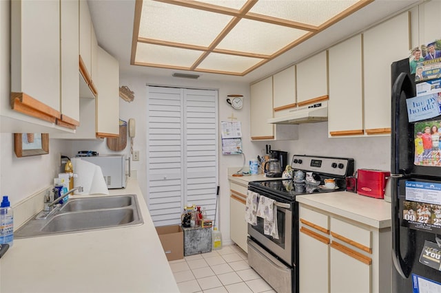 kitchen with white microwave, under cabinet range hood, a sink, freestanding refrigerator, and stainless steel electric range oven