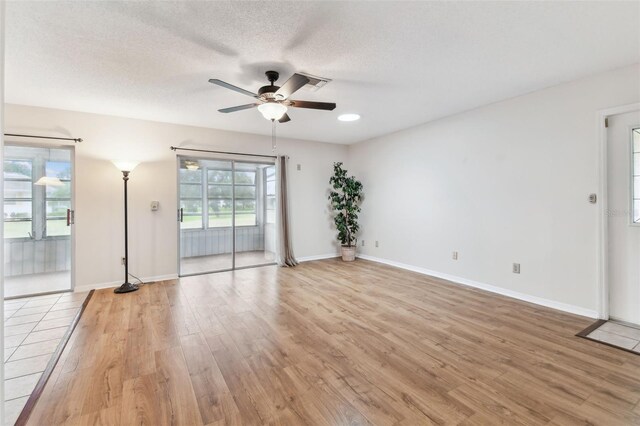 2301 Grenoble Pl Unit 1, Sun City Center, FL 33573 - spare room featuring visible vents, baseboards, ceiling fan, light wood-type flooring, and a textured ceiling