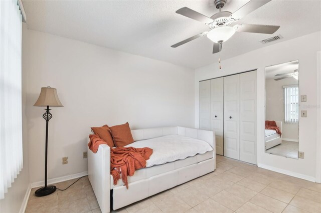 2301 Grenoble Pl Unit 1, Sun City Center, FL 33573 - bedroom featuring visible vents, a closet, baseboards, light tile patterned floors, and a ceiling fan
