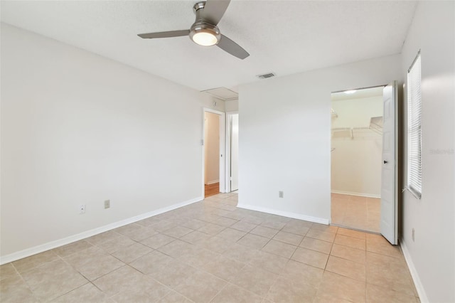 2301 Grenoble Pl Unit 1, Sun City Center, FL 33573 - unfurnished bedroom with visible vents, a closet, a ceiling fan, a walk in closet, and light tile patterned flooring