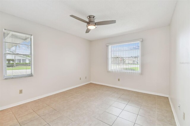 2301 Grenoble Pl Unit 1, Sun City Center, FL 33573 - empty room featuring light tile patterned floors, baseboards, and a ceiling fan