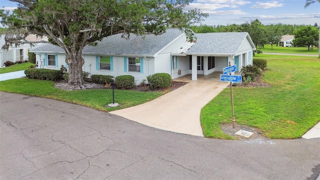 2301 Grenoble Pl Unit 1, Sun City Center, FL 33573 - ranch-style home with a front yard, roof with shingles, driveway, and stucco siding