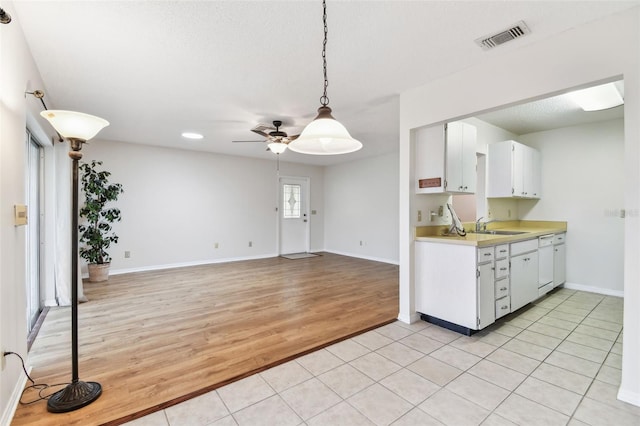 2301 Grenoble Pl Unit 1, Sun City Center, FL 33573 - kitchen featuring white dishwasher, light countertops, visible vents, ceiling fan, and light wood finished floors