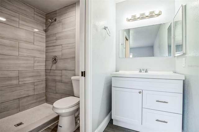 bathroom featuring toilet, a shower stall, vanity, and baseboards