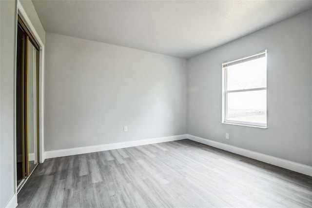 spare room with wood finished floors and baseboards