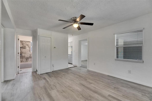 interior space featuring light hardwood / wood-style floors, ceiling fan, and a textured ceiling