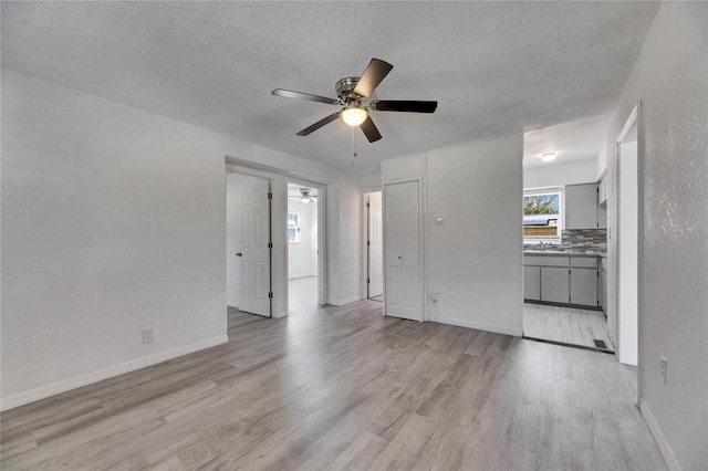 interior space featuring light hardwood / wood-style flooring, ceiling fan, and a textured ceiling