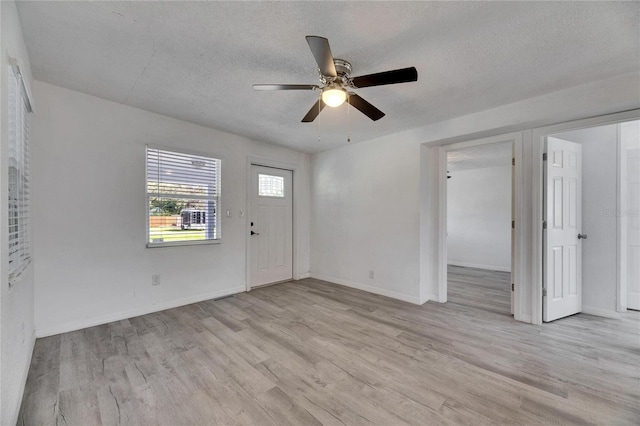 foyer entrance featuring a textured ceiling, ceiling fan, and light hardwood / wood-style flooring