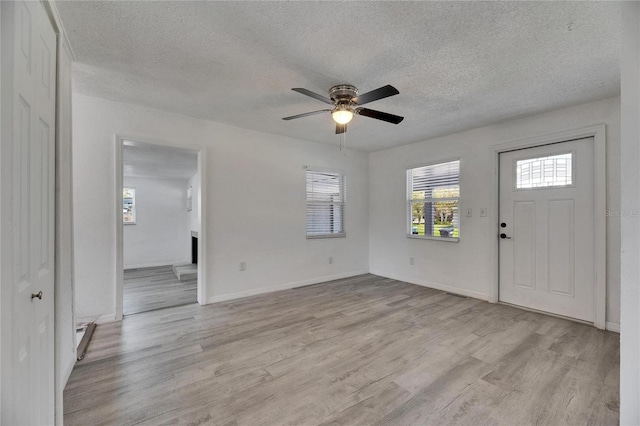 entryway featuring ceiling fan, light wood-type flooring, and a textured ceiling